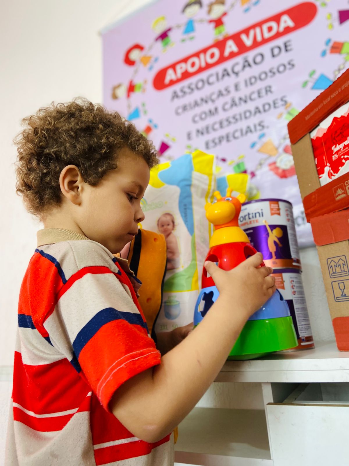 Criança brincando com brinquedo doado pela instituição